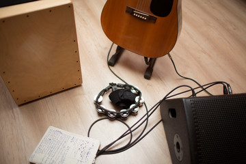a group of musical instruments including a guitar, cajon, tambourine and subwoofer