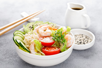 Hawaiian poke bowl with shrimps, rice and vegetables, healthy Buddha bowl with prawns, rice,...