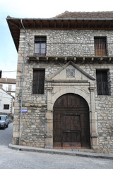 The round arch entrance of a rural stone building with a wooden door in the traditional Pyrenees mountains village of Hecho, in Aragon, Spain