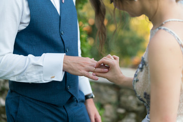 Fototapeta premium bride puts a ring on the groom's finger