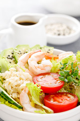 Hawaiian poke bowl with shrimps, rice and vegetables, healthy Buddha bowl with prawns, rice, avocado, cucumber, tomato and lettuce
