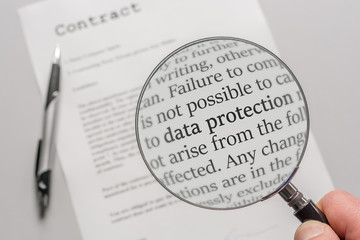 Data protection regulations of a contract are checked carefully with a magnifying glass