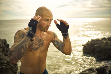 man boxing overlooking ocean