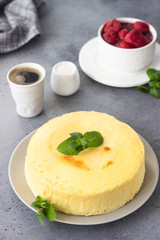 Japanese cotton cheesecake with mint on a grey plate. No crust cheesecake. Grey stone or concrete background. Selective focus, copy space. 