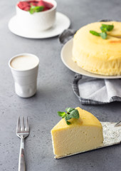 A piece of Japanese cotton cheesecake with mint. No crust cheesecake. Grey stone or concrete background. Selective focus, copy space. 