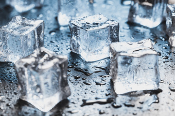 Pieces of ice cubes with water droops on black background. advertising photo
