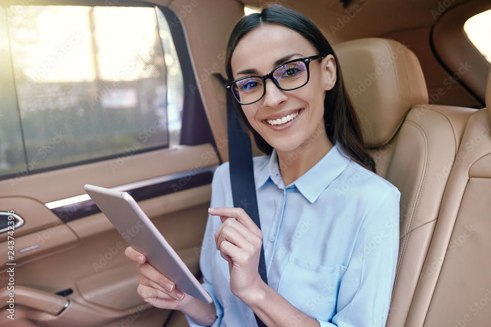 Poster businesswoman using digital tablet sitting in the car