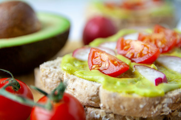 Close-up of toast with avocado, radish and tomato