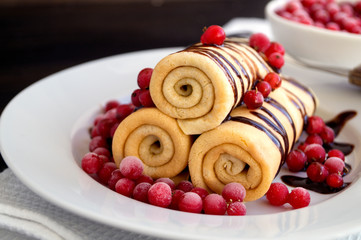 pancakes twisted with berries and chocolate sauce