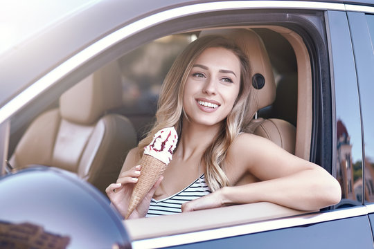 Woman Sitting In The Car And Holding Ice Cream