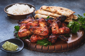 Indian tandoori chicken wings served with pilau rice and garlic naan , selective focus - obrazy, fototapety, plakaty
