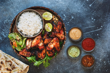 Tandoori chicken wings served with pilau rice,  soft garlic cheese naan with different chutney...