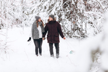 Fototapeta na wymiar Happy young couple in winter park laughing and having fun. Family outdoors
