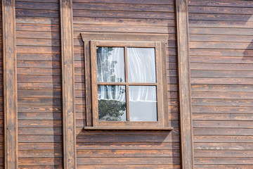 The external window and wall of a vintage wood house in the American West