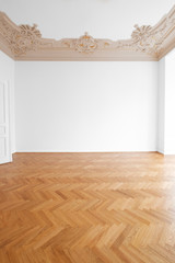 parquet floor , white walls and stucco ceiling in empty room after renovation -