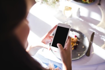 Woman clicking photo of a food on plate
