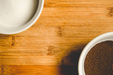 Overhead view of two bowls with sugar and coffee grounds