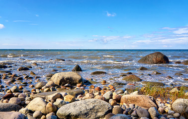 Stony beach with sailboats in the background. Baltic Sea in Mecklenburg-Vorpommern.