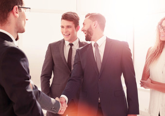 smiling businessman shaking hands with his partner