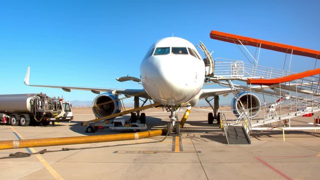 Generic Commercial Jet Airliner Parked with Airplane Ground Support at an Airport on a Sunny Day