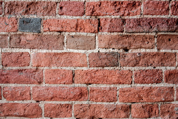 Fragment of the old brickwork close-up. Potholes and defects of red bricks.