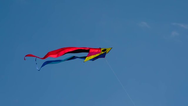 Bright Kite with Two Tails. Bright multicolored kite gaily fluttering against the sky. Filmed at a speed of 240fps