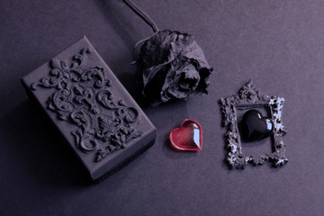Black glass heart and black rose. Metal head, punk, emo lovers background.