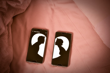 deux images d'amoureux sur des téléphones posés sur un lit et des draps rouges