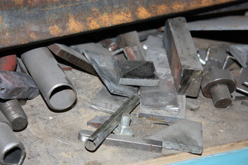 Steel bars and pipes in the ​cluster on a workshop shelf. 