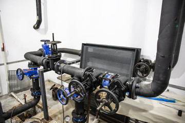 House heating system with many steel and plastic pipes, metal tubes and automated control equipment