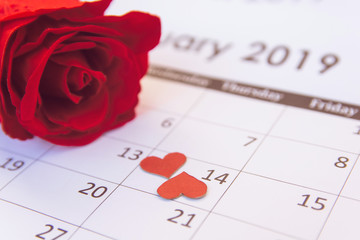 Valentines day. Red rose and red hearts on Calendar page February 14 with copy space