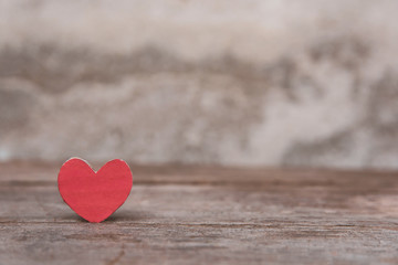 Fototapeta premium Valentines Day background with red heart shape on dark wooden background with copy space