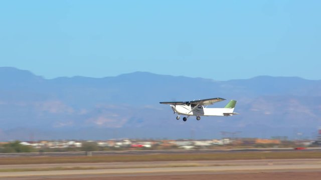 Private Small Generic Airplane Taking Off from Airport Runway with a Blue Layered Mountains Background on a Sunny Day in the Southwest