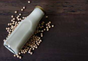 Soy milk bottle on dark wooden background. Space to copy.