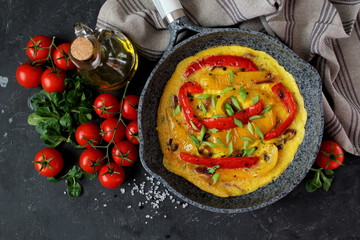 Frittata with sweet peppers in iron pan. Top view with copy space. Omelette with vegetables.