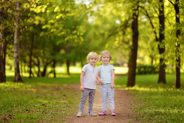 Fototapeta premium Cute little children playing together and holding hands in sunny