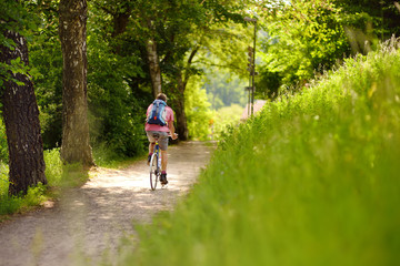Obraz premium Sportive man cycling in sunny park in hot summer day. Switzerland, Europe