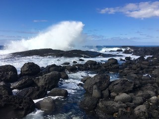 Waves crash into lava rock during high surf