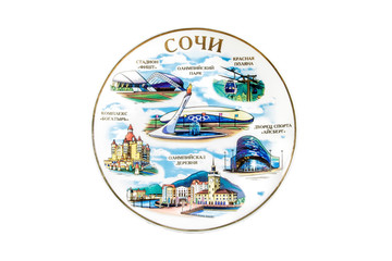 ceramic souvenir toy in the form of plate with beautiful color painting on isolated white background reflecting the national Russian culture with the inscription in Russian: Sochi Olympic village