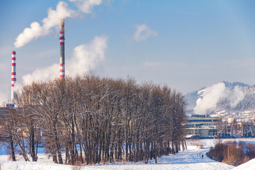 Smoke chimneys from the factory during the winter during the sunny day.