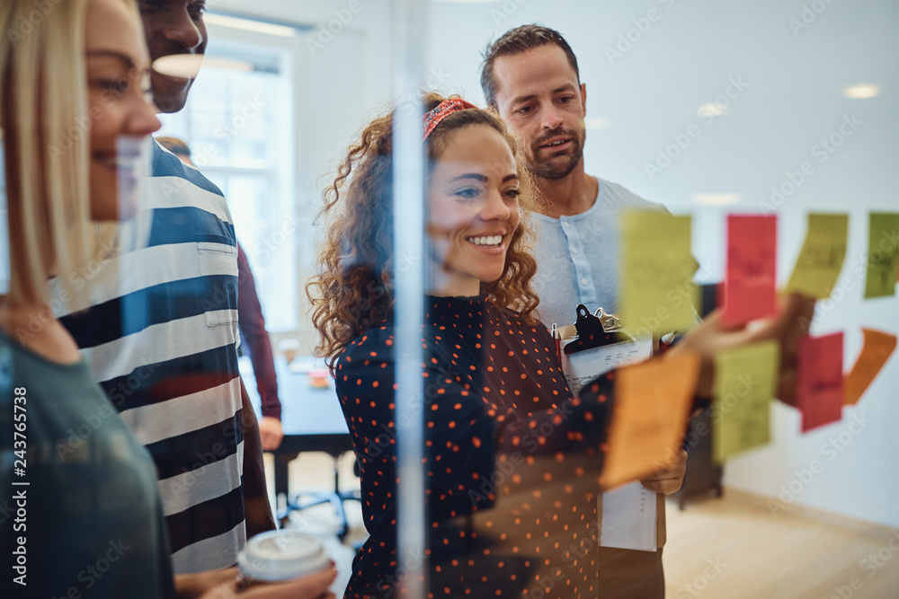 Wall mural smiling designers having a brainstorming session in an office
