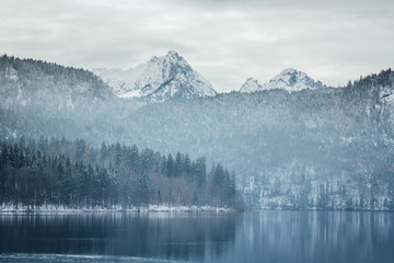 Amazing winter landscape of alpine lake with crystal clear water and mountains in background - obrazy, fototapety, plakaty