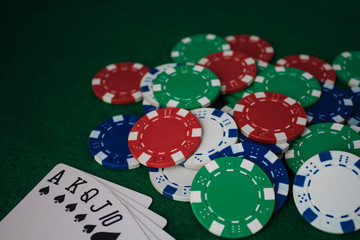 Hand of Poker, straight flush and chips on a felt green background. Top view and copy space.