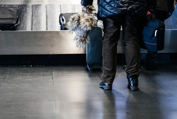 Rear view of senior couple preparing to take luggage from the conveyor belt