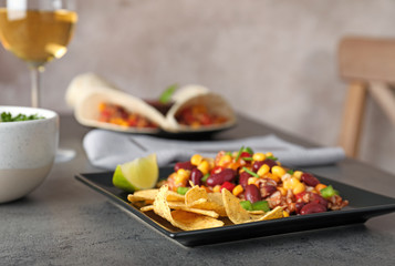 Plate with tasty chili con carne served on gray table
