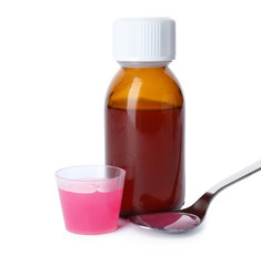 Spoon, measuring cup and bottle of cough syrup on white background