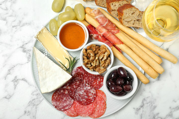 Flat lay composition with wine and snacks on marble background