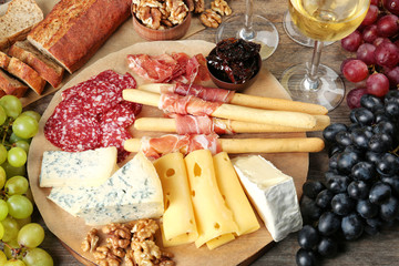 Composition with wine and snacks on wooden background