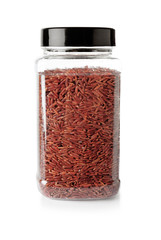 Jar with uncooked brown rice on white background