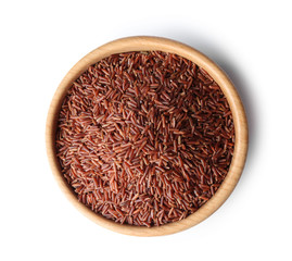 Bowl with uncooked brown rice on white background, top view